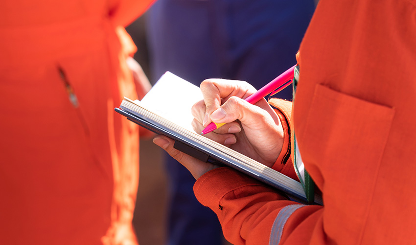 orange suit write in notebook